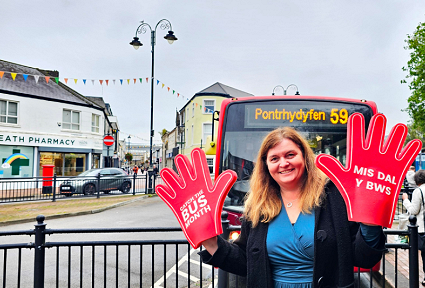 Sioned WIlliams campaigning to save buses at a bus stop