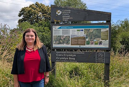 sioned williams next to the crymlyn bog sign