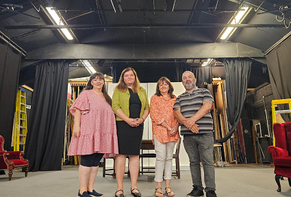 Mae Sioned Williams MS yn sefyll gydag aelodau o Theatr Fach Neath ar y llwyfan yn y lleoliad sydd bellach ar gau.