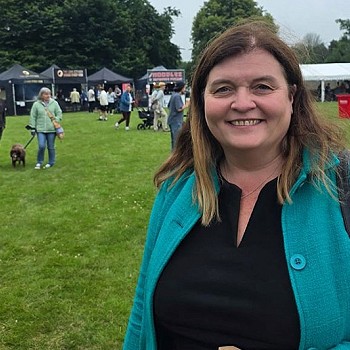sioned williams yn gwenu mewn cae