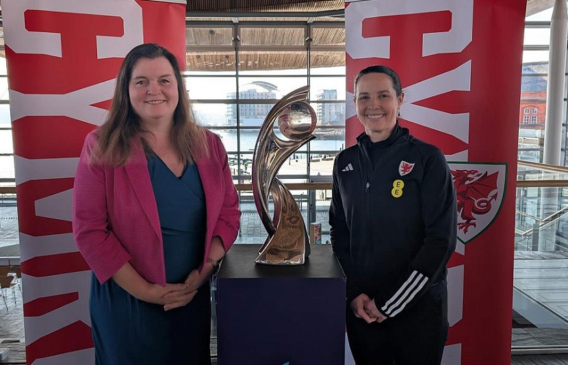 Sioned Williams yn sefyll wrth ymyl tlws Cymru