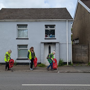 Sioned and Beca and a lady picking litter on a street