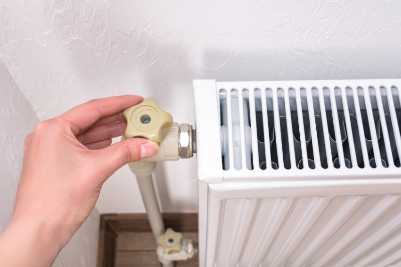 llaw yn troi'r bwlyn ar radiator