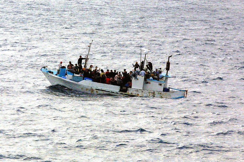 Cwch yn llawn phobl yn sefyll yn ganol y mor