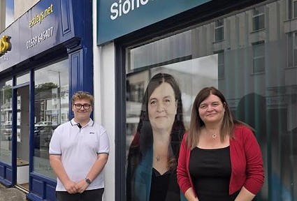 Sioned a Reggie y tu allan i'r swyddfa