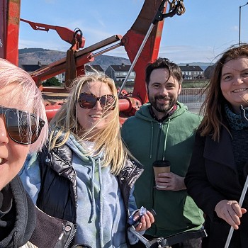 Grŵp o bobl gyda ffyn casglu sbwriel yn barod i ddechrau