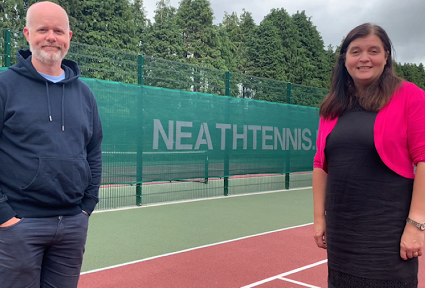sioned with a man at a tennis court