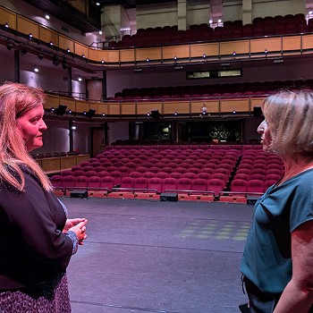 Sioned standing on the stage speaking to a lady