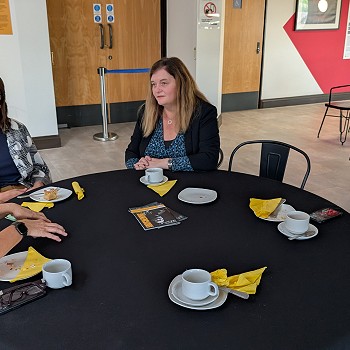 Sioned sitting at a table speaking to three ladies