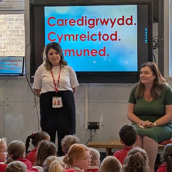 Sioned sitting and speaking to school pupils in an assembly